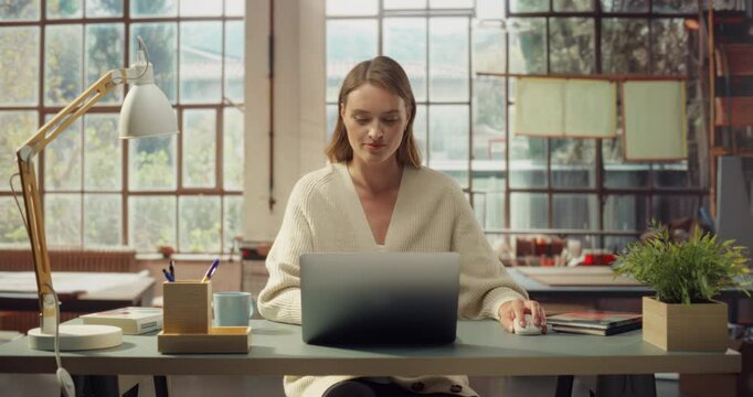 White Woman in Cozy Sweater Uses Her Laptop. Successfull White  Woman Working on Computer, Doing Digital Company Marketing, Creative Writing, Coding, Research. Front View Portrait