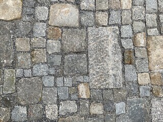 Blick von oben auf handgehauenes und handverlegtes Kopfsteinpflaster mit  unterschiedlich großen...