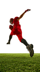 Back view image of man, American football player in red uniform in motion on field, running with...