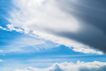 Fototapeta premium Blue sky landscape with dramatic clouds lit by evening sunlight