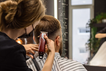 Step-by-step training of men's haircuts. Step 4. Female hairdresser clippers client in hairdressing...