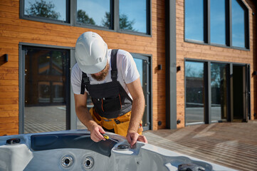 Plumber installing hot tub. Spa technician performing hot tub. Bathtub plumbing. Plumber fixing spa...