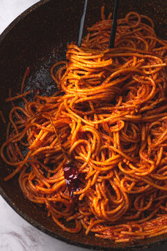 Spaghetti all'assassina is a typical Apulian recipe, Bari. Trendy first course, pasta cooked directly in a pan with tomato sauce, for a charred, crunchy and spicy flavor, close up, new Italian pasta