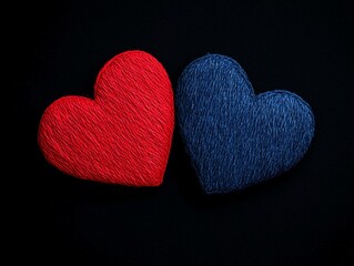 Two handcrafted hearts, one red and one blue, on a black background.