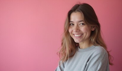 Obraz premium Young woman with cheerful smile posing against pink background with copy space