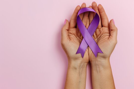 Purple ribbon in female hands. World cancer day