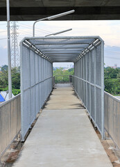 Fototapeta premium Metal mesh on steel walkways or caged in walkway over passing highway and railway.