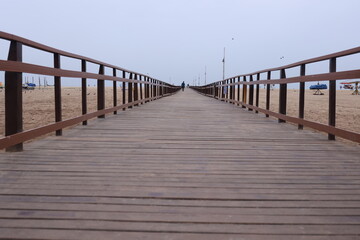 Boardwalk wooden pathway at marina beach in Chennai. a ramp for disabled to reach the beach waters