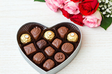 ハートの箱に入ったチョコレートと赤いバラとピンクのバラ