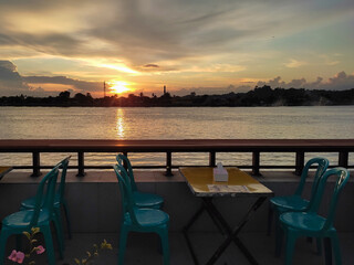 A relaxing spot with tables and chairs set up to enjoy the sunset by the banks of the Segah River in Berau, East Kalimantan.