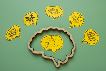 Brain outline with sun inside and negative emotions outside. Inner positivity or mental resilience.