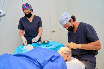 Doctors performing hair transplant surgery procedure
