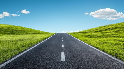 Fototapeta premium A serene road stretches into the horizon, bordered by vibrant green fields under a clear blue sky with fluffy clouds.