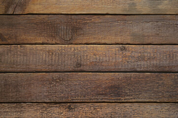 Obraz premium A brown background of wooden boards, with a variety of brown shades. The boards are slightly worn, which adds a sense of naturalness and antiquity. Ideal for backgrounds in designs, advertisements