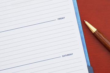 Empty day planner with Friday and pen on desk