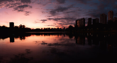 Fototapeta premium Sunset landscape of a lake with a city in the background