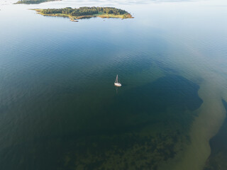 A sailing yacht is anchored off the coast of the Estonian island Krasuli on a summer day, photo...