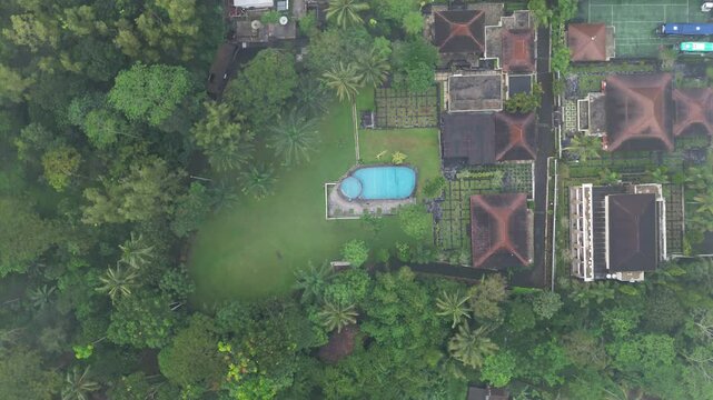Aerial View of a Villa with a swimming pool on a Plateau Surrounded by trees