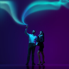 Man and his assistant in formal suits, interacts with flowing waves of digital data, symbolizing...
