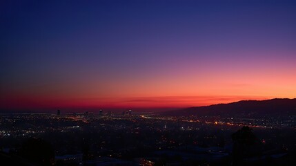 Naklejka premium Sunset over Santa Monica Pier, capturing the vibrant colors of the sky and city lights starting to twinkle.