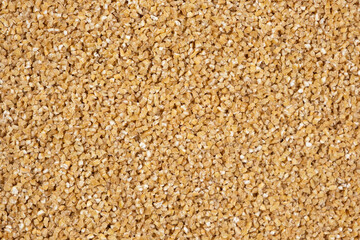 Background of raw uncooked wheat groats, macro top view