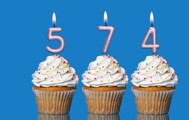 Birthday Cupcakes With Candles Lit Forming The Number 574