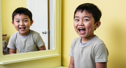 Caucasian boy making funny faces in front of a mirror playful demeanor casual clothes solid light yellow background chubby build child
