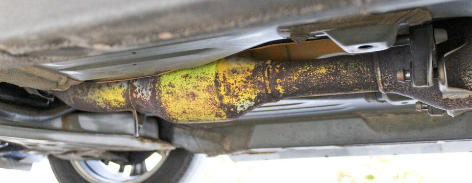 close up of a metal spray painted yellow catalytic converter background