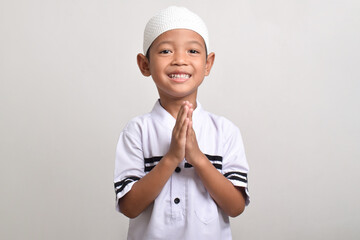 Asian Muslim boy posing to give Ramadan greetings isolated on white background