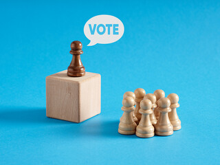 Leader chess pawn at the rostrum gives the message of Vote to the crowd of audience.