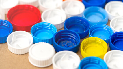 A collection of plastic caps in various colors. The caps are arranged in a pattern, with some...