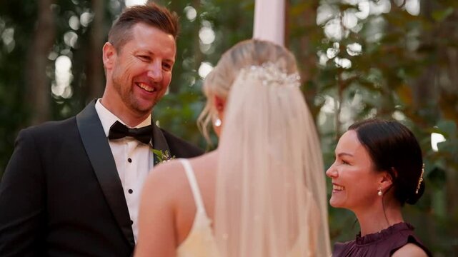 Groom In Black Tuxedo Suit Smiling During Romantic Outdoor Wedding Ceremony, 4K Slow Motion