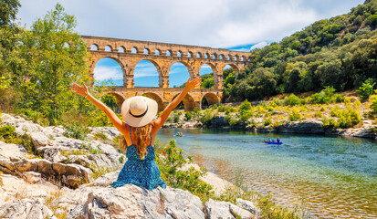 Happy woman tourist enjoying famous touristic site in France, Pont du Gard.