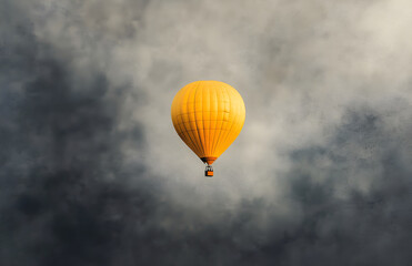 Fototapeta premium Yellow Hot Air Balloon in Cloudy Sky