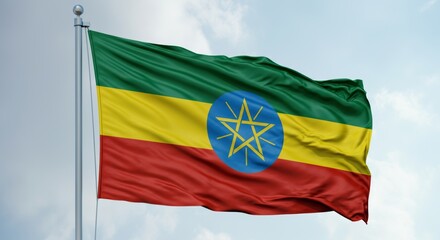 Ethiopian flag flying in blue sky displaying green, yellow, red stripes and national emblem.