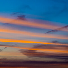 Heaven etude, Sunlit orange trails of plains in blue sky at sunset