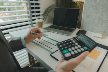 Typical office work atmosphere for company employees. A businessman is diligently handling important documents in his personal office. Important project report documents are being analyzed by experts.