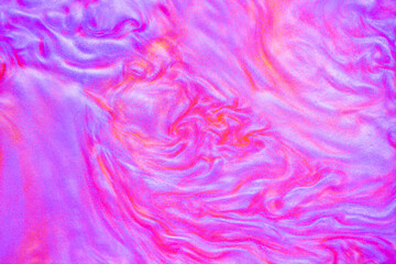 Shimmering multicolor abstract background. Liquid glitter paint texture waves and swirls. Beautiful shiny blue and pink glitter texture. Metallic paint close-up as a holiday background.