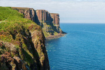The dramatic basalt columns of Kilt Rock stand tall against the vast blue expanse of the Sound of Raasay on the Isle of Skye's Trotternish Peninsula.