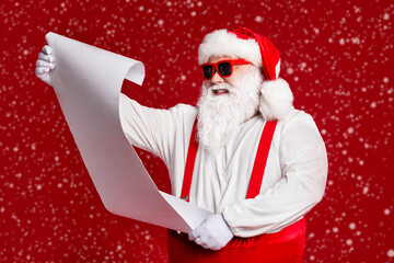 Portrait of his he attractive cheerful fat white-haired Santa father reading long wish present gift...