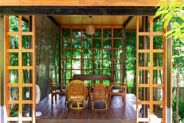 Japanese-style wooden pavilion surrounded by lush bamboo trees