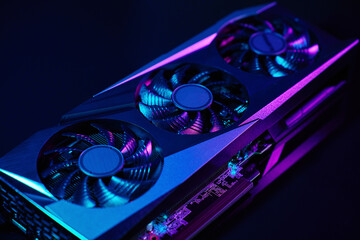 Close-up of high-performance graphics card with three cooling fans with neon lighting. Modern video...