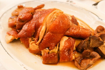 close up of Chinese smoked chicken with soy sauce on a white plate