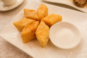 Close up of Chinese Cantonese traditional food deep fried custard of Chicken broth soup with sweet sugars on the side