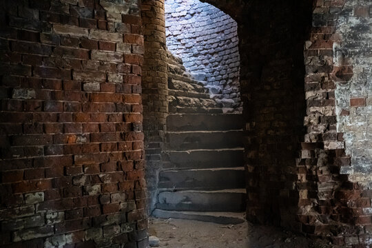 A narrow spiral brick staircase in the Bobruisk fortress. Sunlight inside