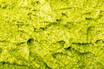 Green yogurt ice cream with pistachios, kiwi and avocado. Fresh fruit smoothie. Ice cream texture. Delicious sweet dessert close-up as background.