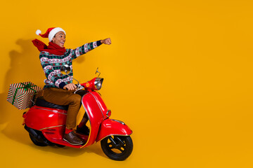 Full size photo of nice young man ride giftbox scooter empty space christmas isolated on yellow...