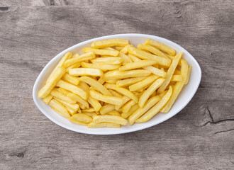 French fries in a plate over wooden table