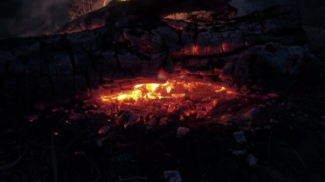 Smoldering embers from a bonfire on a black background. Burning bonfire in the night forest. Tourist, hiking, nature futage