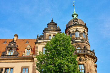 Historic building in Dresden with striking tower, ornate architectural details and red tiled roof...